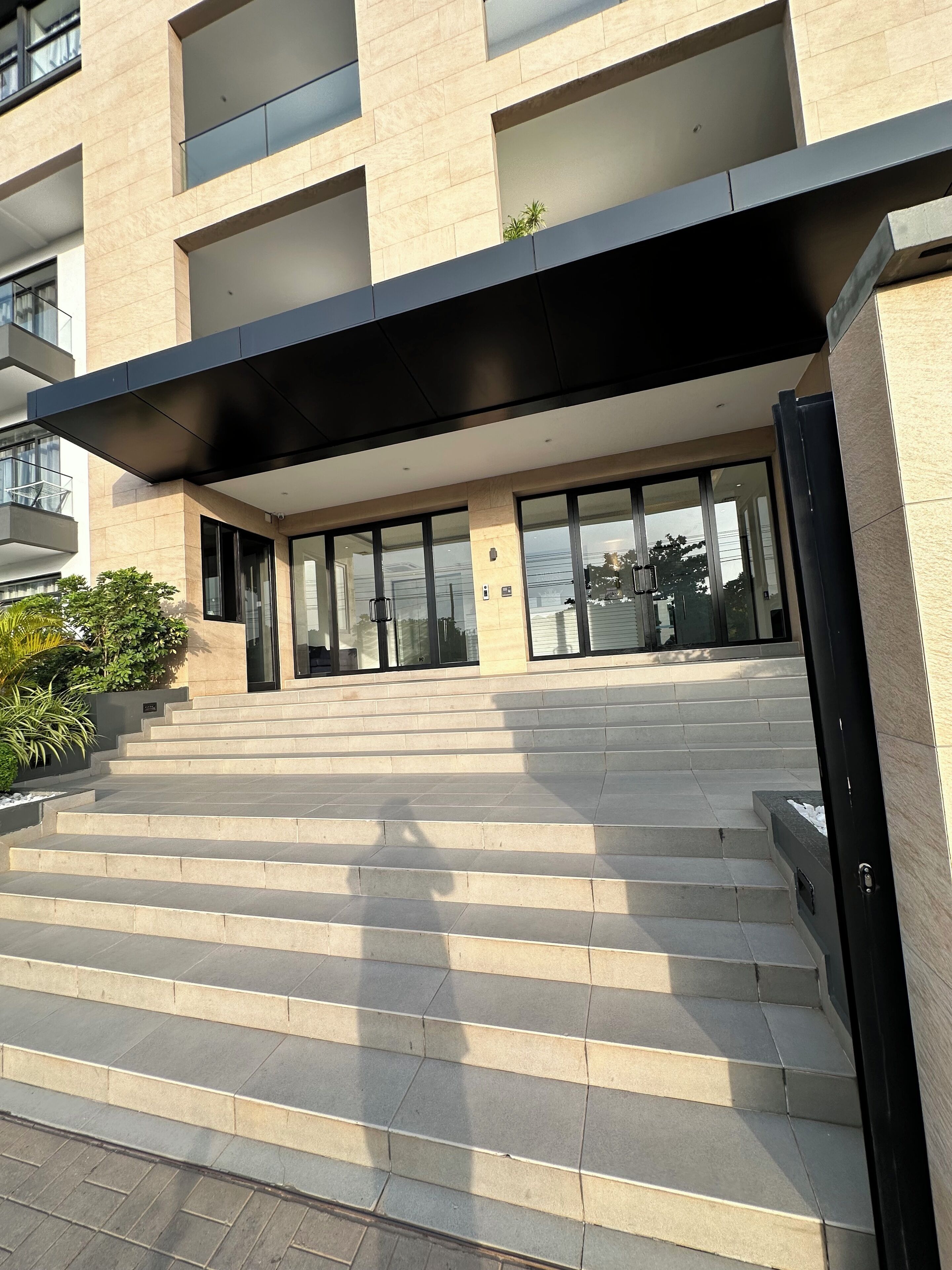 A modern building with a staircase leading to a glass entrance.
