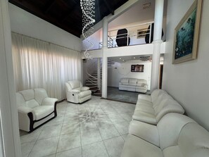 Deluxe House, Pool Access, Pool View | Living area | 65-inch Smart TV with digital channels, Netflix, pay movies - Casa Luxo da Praia - Ponta das Canas (Florianópolis)