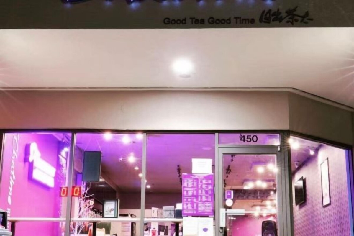 L’intérieur d’un salon de thé, décoré dans des tons violets, avec une porte en verre et un numéro de chambre bien visible : 450.