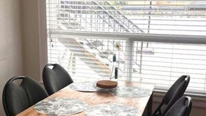 A dining table with four chairs and a central decorative item. - Vancouver Garden Hotel (Richmond)