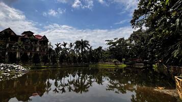 A calm lake with reflections of trees and a building with a red roof.
