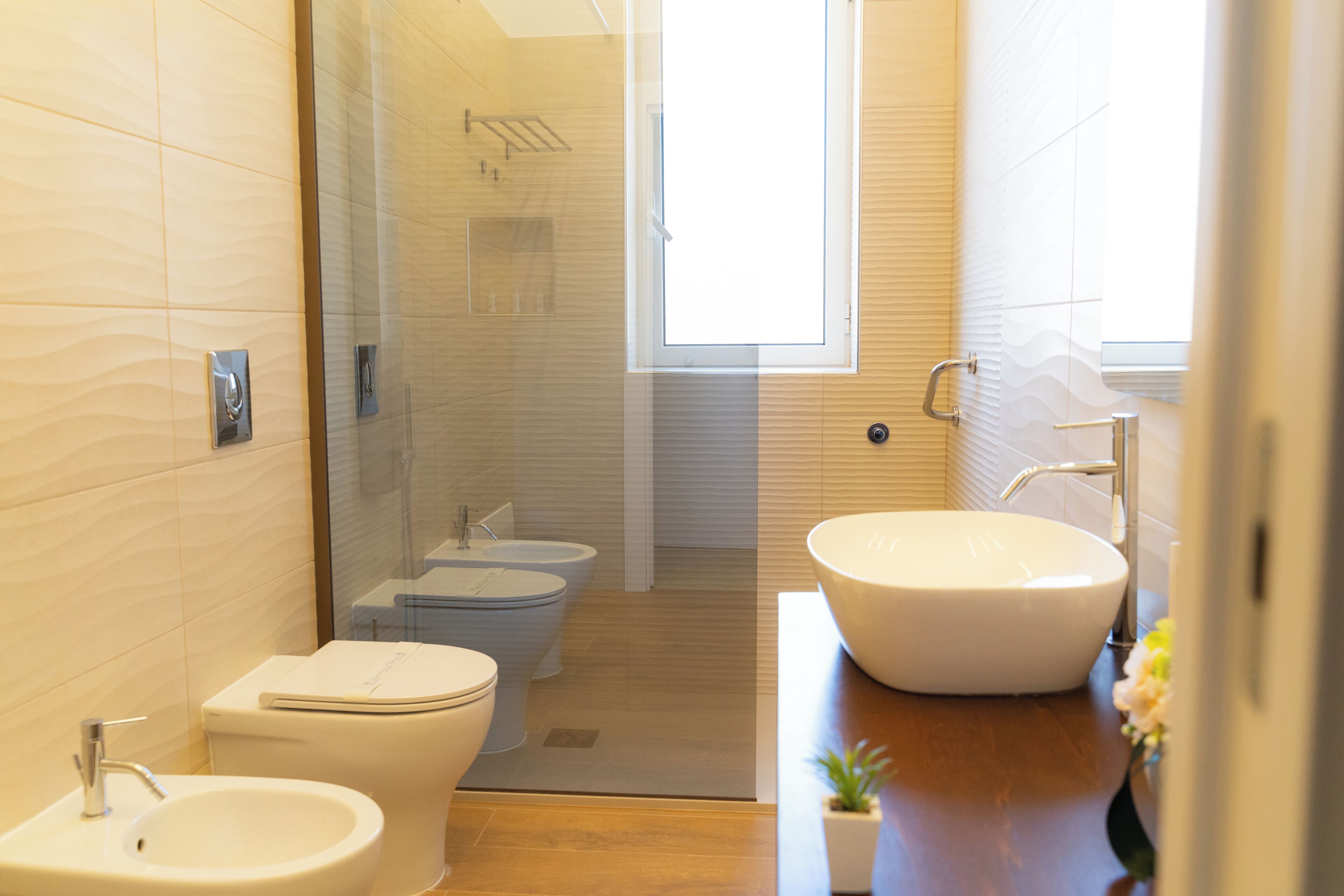 A modern bathroom with a bidet, toilet, and sink.