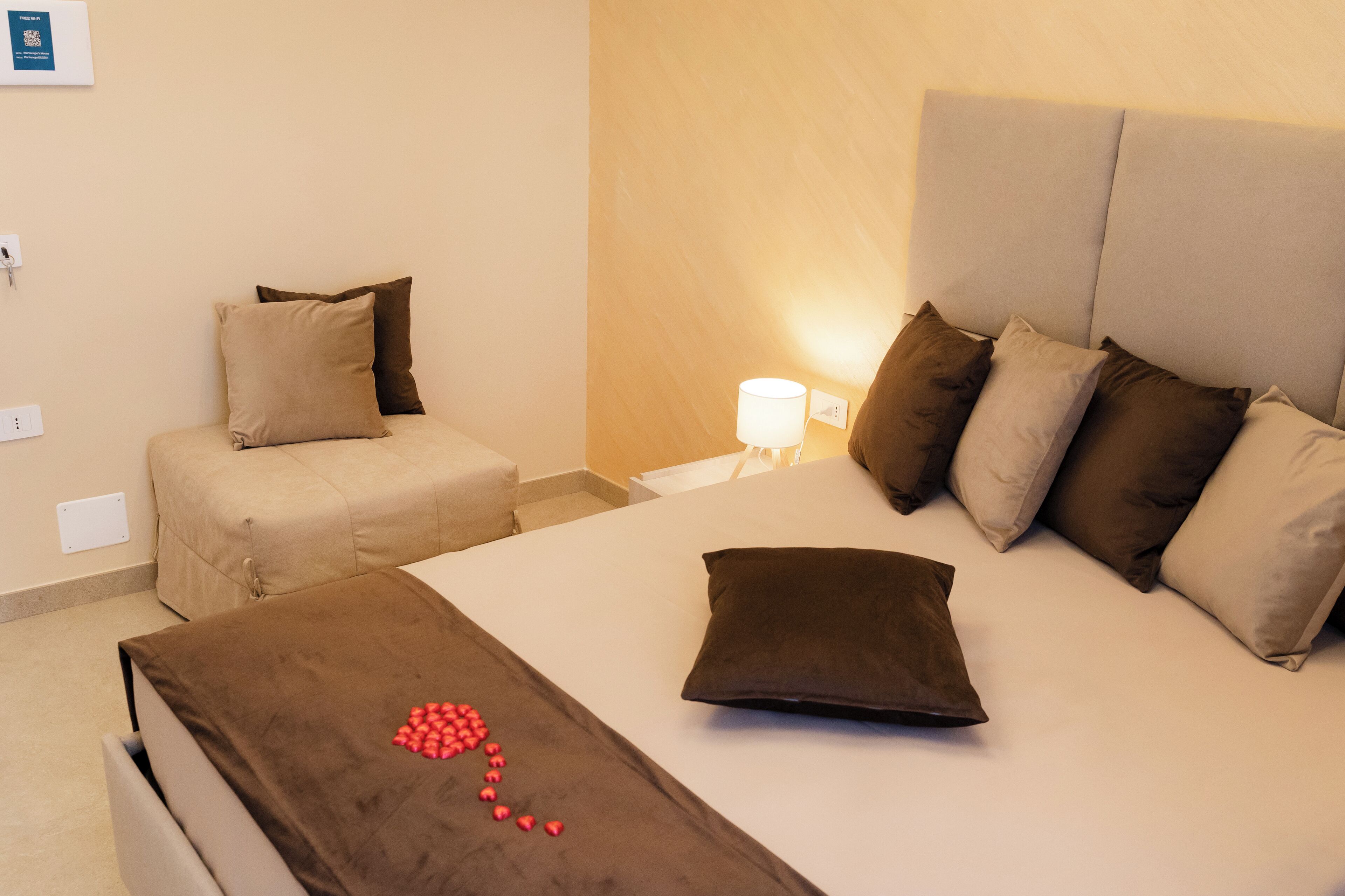 Ein Hotelzimmer mit einem Bett, einer Couch und einem Nachttisch mit einer Lampe.