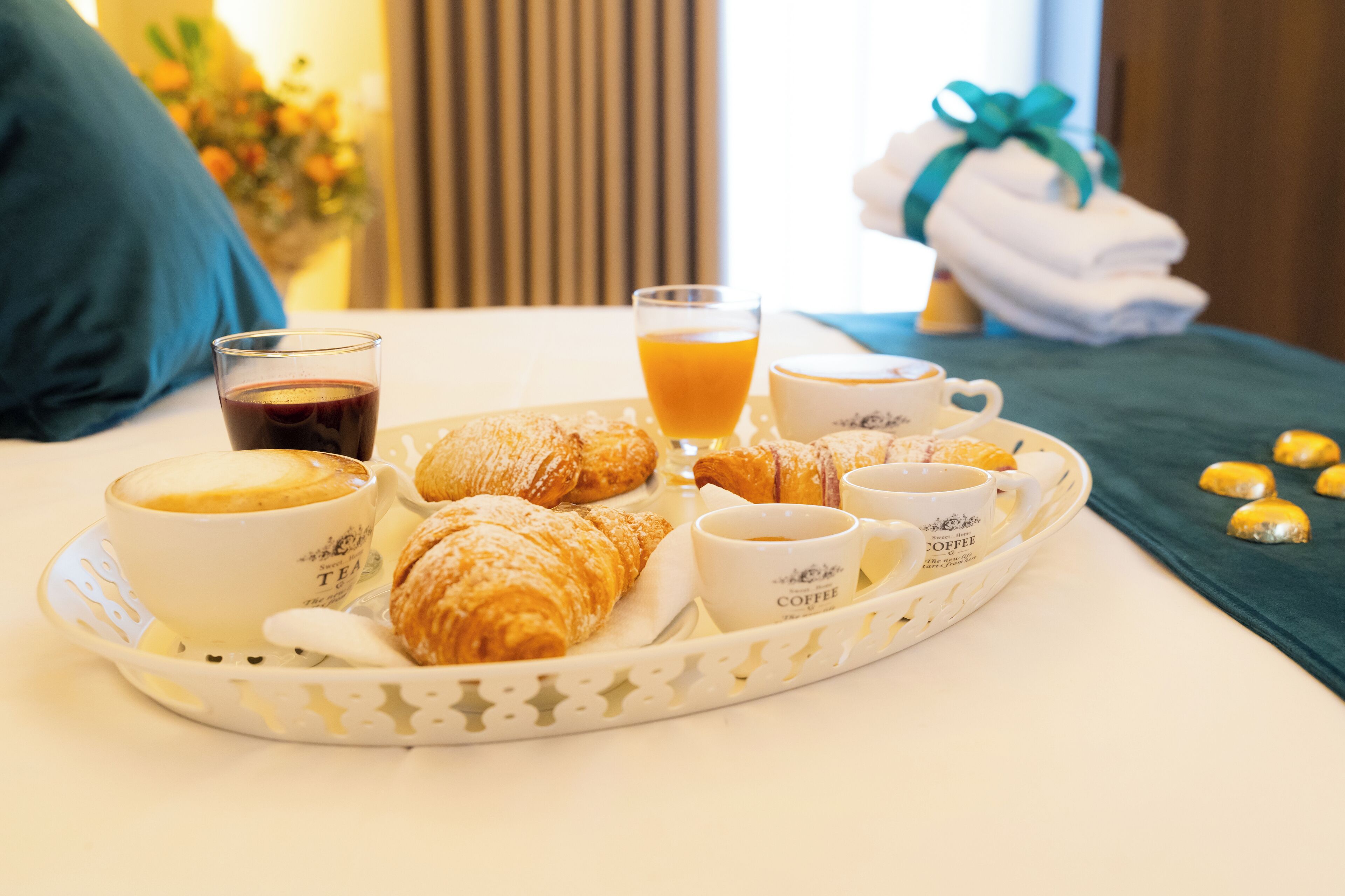 A breakfast tray with croissants, coffee, and orange juice on a hotel table.
