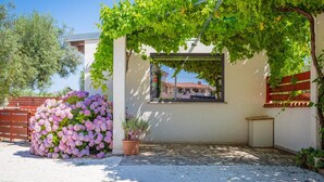 A garden with a pergola, a window with a view, and a gravel path.