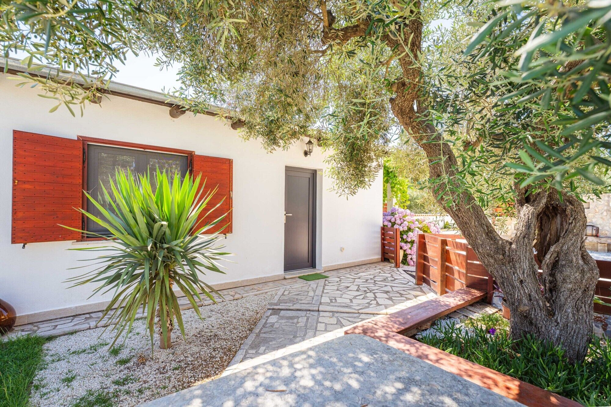 A house with a patio, a door, and a tree.