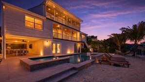 A two-story house with a swimming pool, outdoor bar, and lounge chairs. - NEW! Waterfront + Sauna + Pool + Pet Friendly +Gym (Anna Maria)