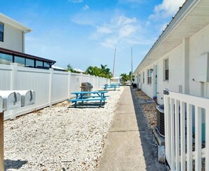 A row of white mobile homes with numbered mailboxes, picnic tables, and a gravel pathway. - Waterfront-Family & Pet Friendly for 6 (Apollo Beach)