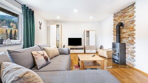En moderne stue med sofa, fjernsyn og pejs.