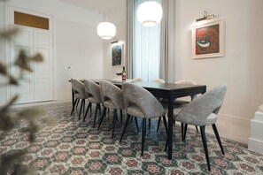 A dining area with a table, chairs, and artwork on the walls.