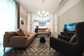 A modern living room with a sofa set, a coffee table, and a TV.