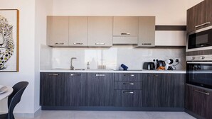 Une cuisine moderne avec des meubles en bois foncé, un plan de travail blanc et des appareils électroménagers en acier inoxydable.