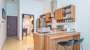 Una cocina moderna con una isla central, electrodomésticos de acero inoxidable y armarios de madera.