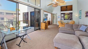 A spacious living area with a glass desk, a comfortable sofa, and a ceiling fan. - Kksr#6301 Ocean/Golf Course Views, Top Floor, Corner Unit, Cathedral Ceilings (Kailua Kona)