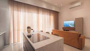 A modern living room with a marble island, a sofa, and a flat-screen TV.
