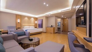 A modern hotel room with a bed, seating area, kitchenette, and a TV. - Garden Holiday Hotel (Guilin Liangjiang Sihu University of Technology) (Guilin)