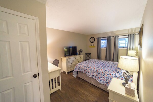 A bedroom with a bed, dresser, desk, and a television. - Discover Unmatched Convenience in This Cozy 2-Bedroom Condo (Sugar Mountain)
