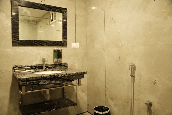 Une salle de bain avec un lavabo en marbre, un miroir et une douche.