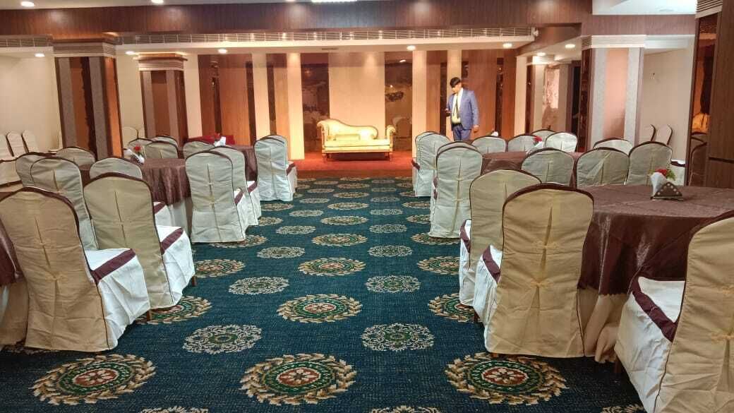 A conference room with rows of chairs, a carpeted floor, and a central stage.
