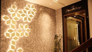 A modern interior with a textured wall and a geometric light fixture. A potted plant is visible near a staircase leading to a room labeled "The Platinum Lounge." - The Platinum Boutique Inn Hotel (Hyderabad)