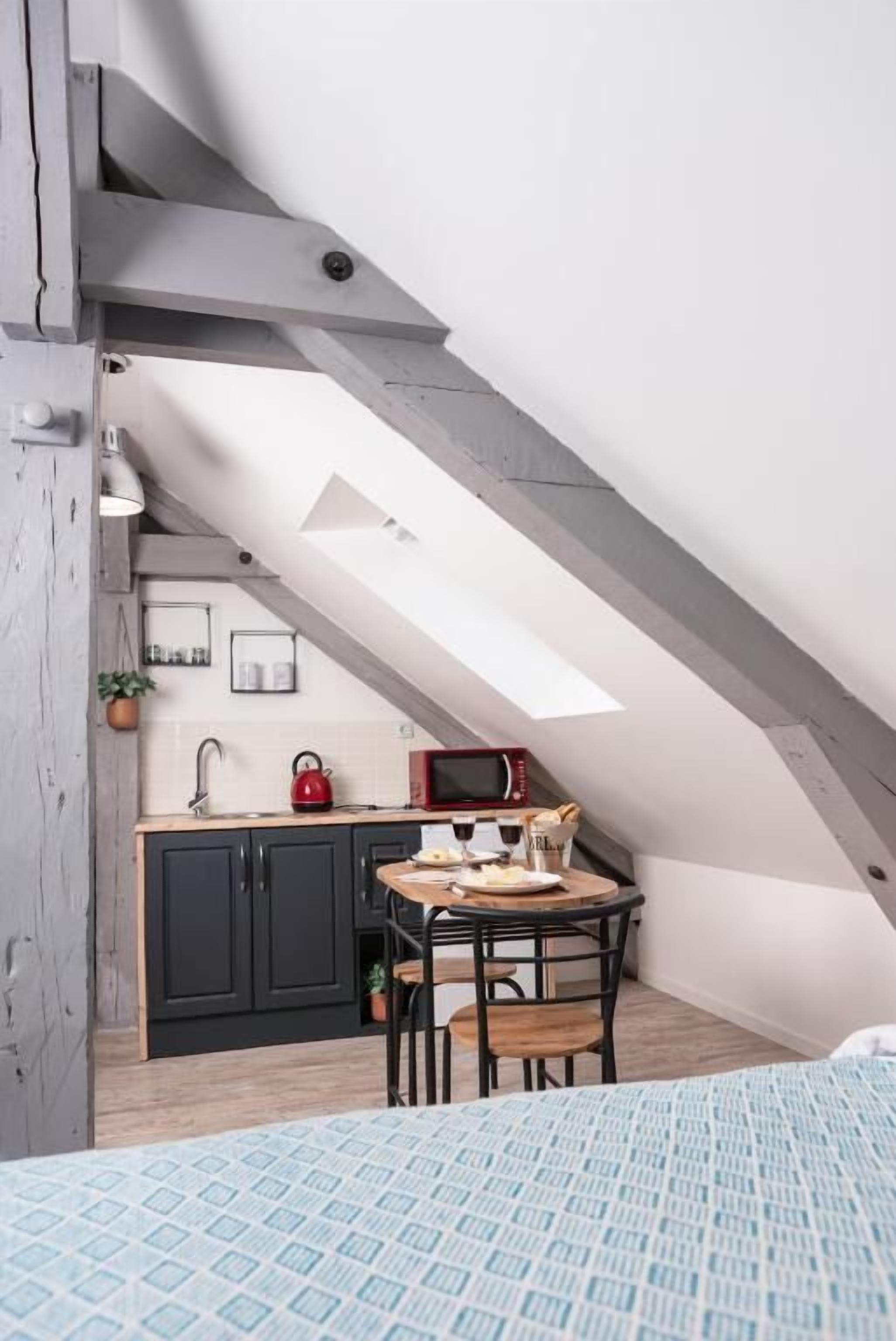 A compact kitchen with a dining area, a microwave, and a kettle.