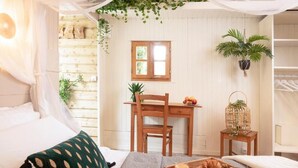A cozy room with a bed, a desk, and a small table with breakfast items. - Les Glycines de Monchy (Monchy-Humieres)