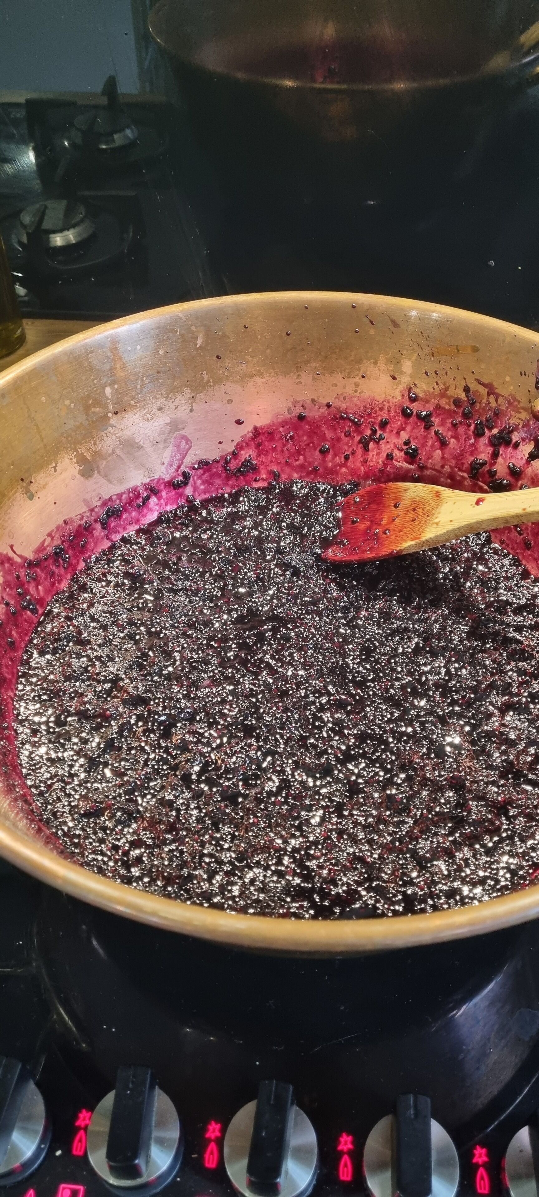 A cooking pan with a dark, bubbling mixture on a stove.