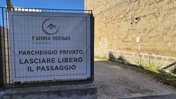 Schild für 'Farina Rooms & apartments' mit einem privaten Parkplatz und einem Durchgang.