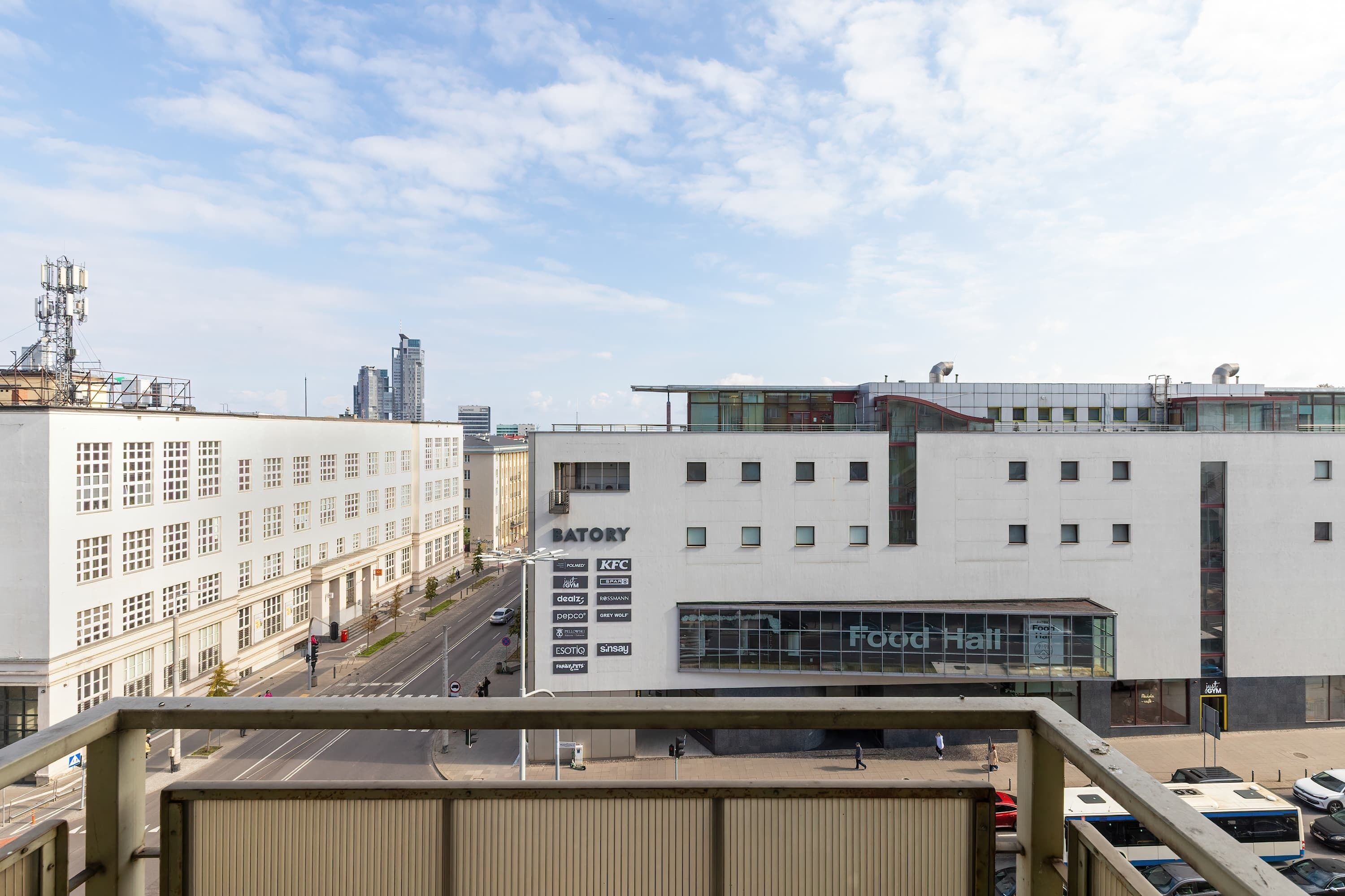 A modern building with a large glass facade, a sign for a food hall, and a KFC restaurant.