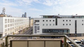 Un edificio moderno con un amplio muro de cristal, un cartel que indica una zona de comidas y un restaurante KFC.