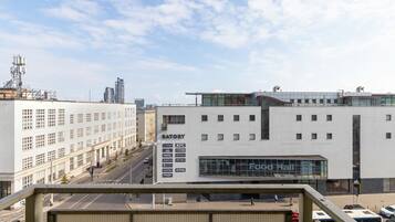 A modern building with a large glass facade, a sign for a food hall, and a KFC restaurant.