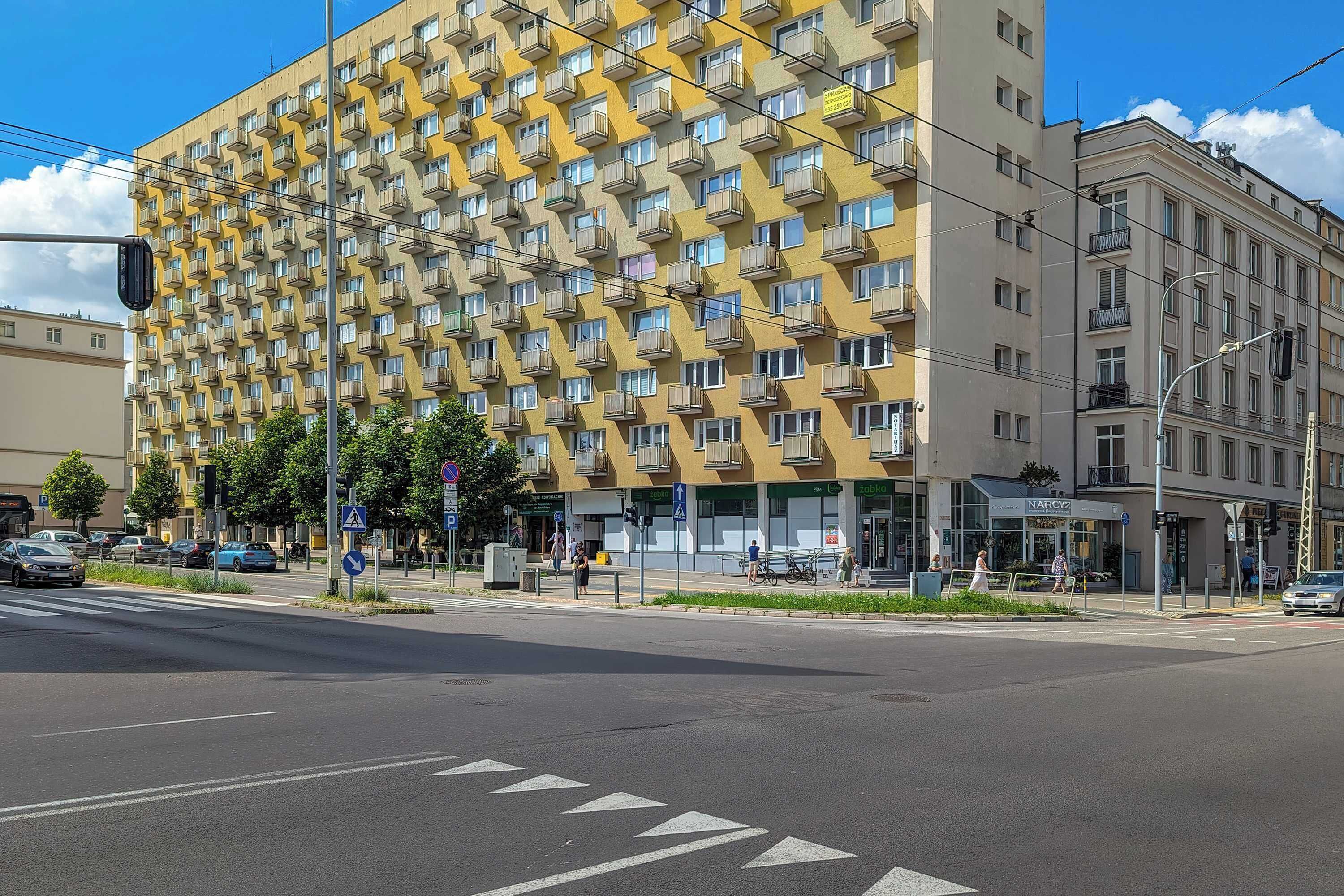A multi-story building with a distinctive geometric facade, featuring numerous balconies.
