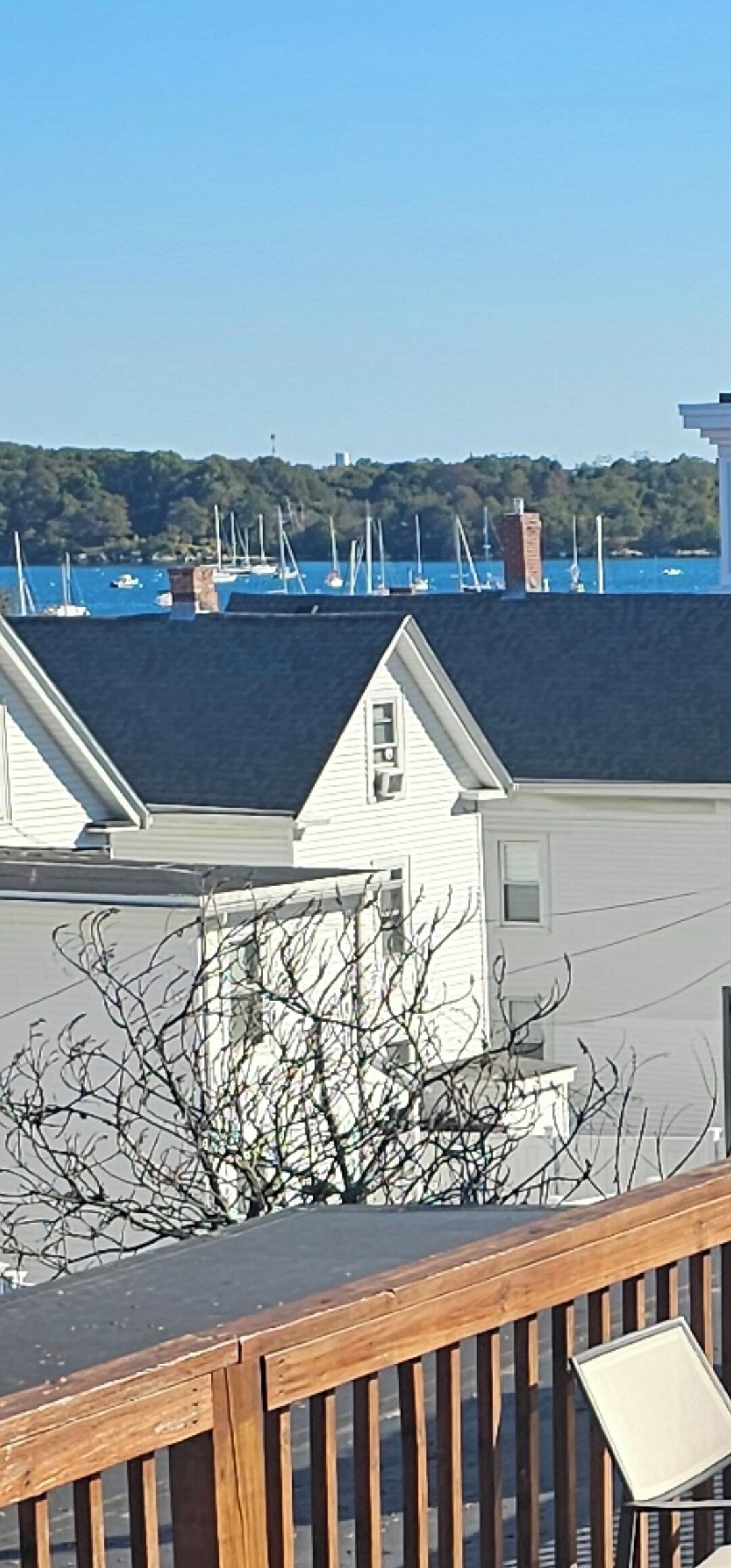 A view of a marina with boats and a white building with a dark roof.