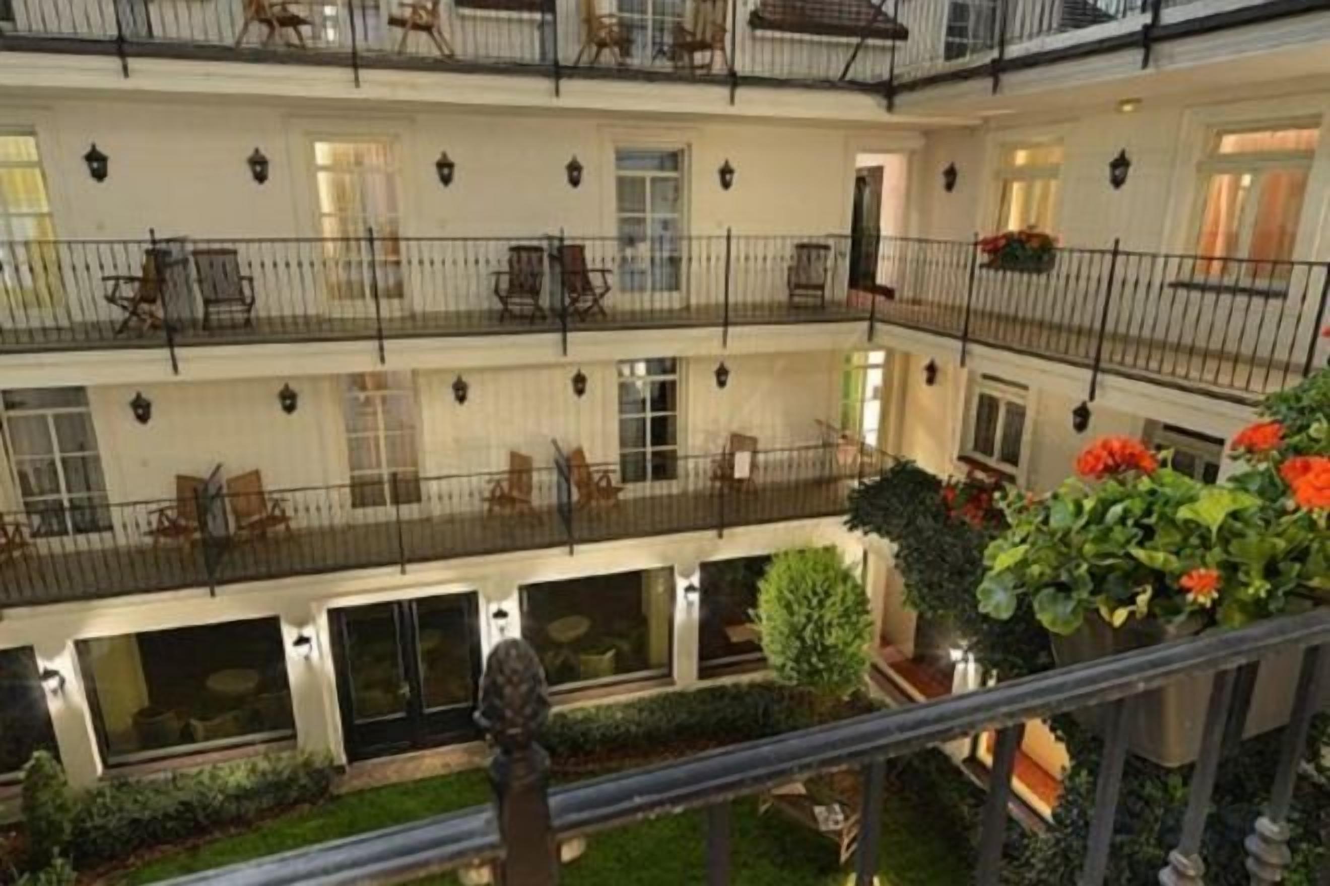 Ein mehrgeschossiges Hotelatrium mit Balkonen, Sitzgelegenheiten und Zimmerpflanzen.