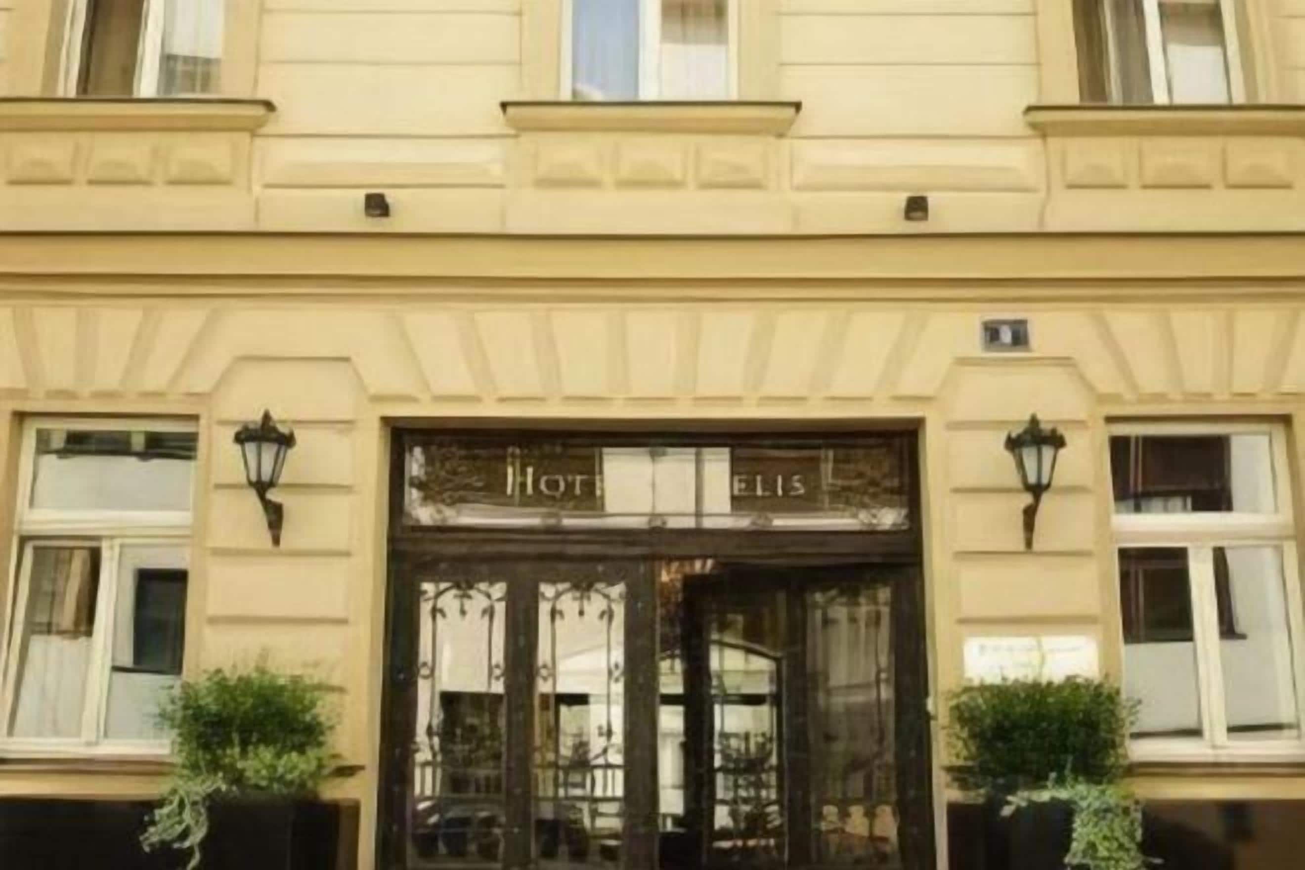 Entrada de hotel con puertas dobles y un cartel que dice 'Hotel Elis'.