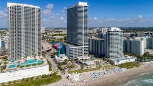 Un complejo hotelero de gran altura con varias edificaciones, piscina y zona de playa.