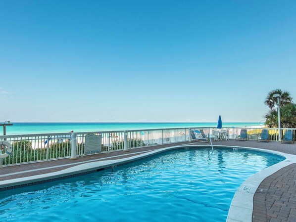 A swimming pool with a view of the beach and ocean.