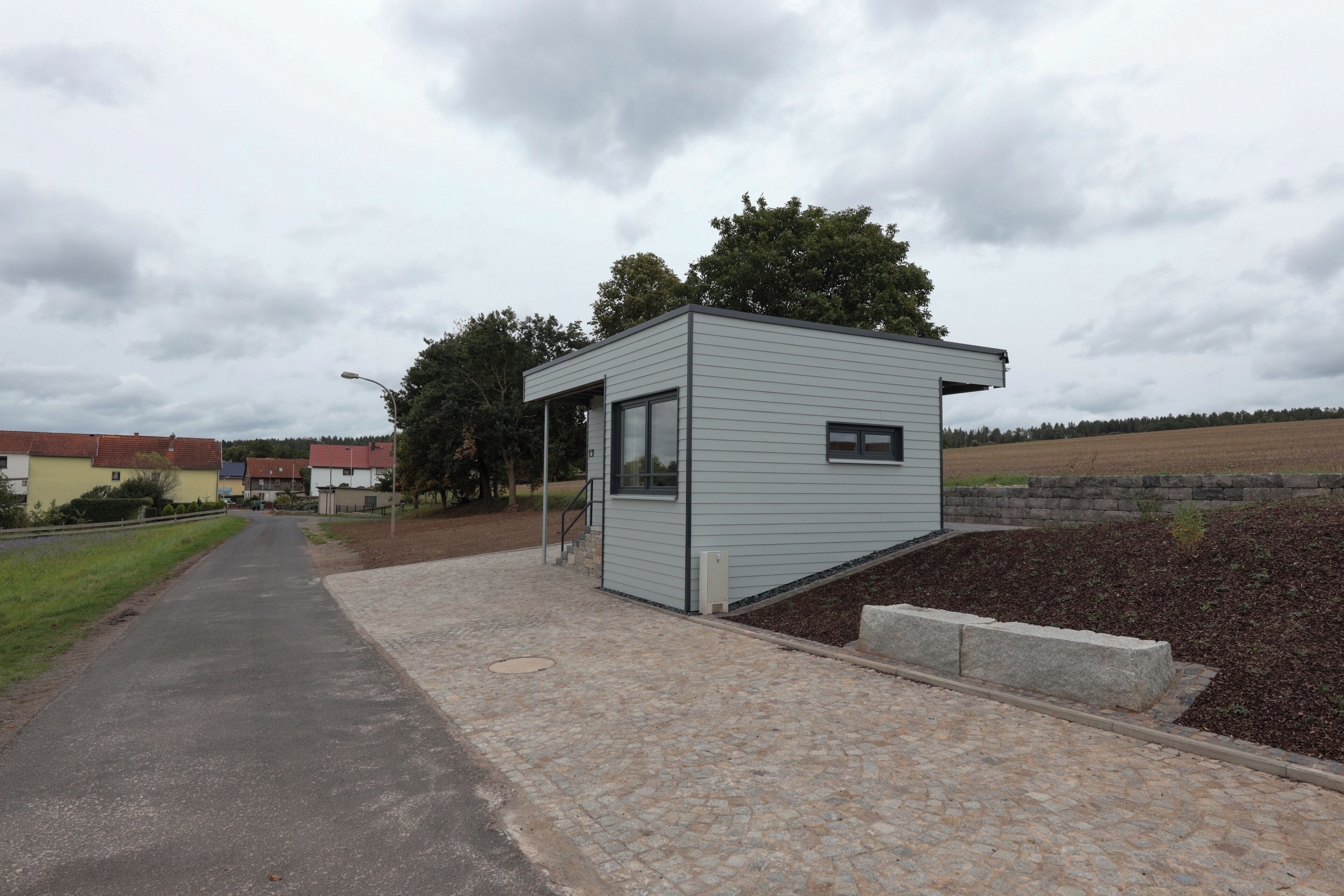 A small, single-story building with a flat roof, a door, and a window.