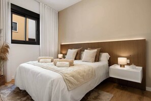 Une chambre moderne avec un grand lit, des tables de chevet et une fenêtre avec des rideaux.