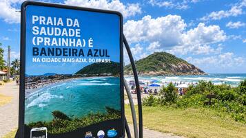 Un letrero con una playa y texto en portugués.