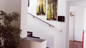 A staircase with a handrail, a potted plant, and two framed pictures on the wall. - Motel Graz Ost  (Graz)
