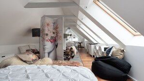 Tilava parvi, jossa on korkea katto, kattolasikatto ja näkymä viereiseen ruokailutilaan.