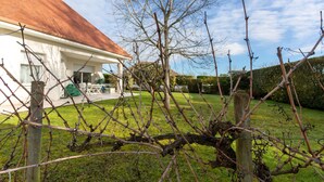 A house with a red roof, a fenced yard, and a hedge in the background. - Guest Room in Laroin for 2 to 4 Guests – Nature and Tranquility Await (Laroin)