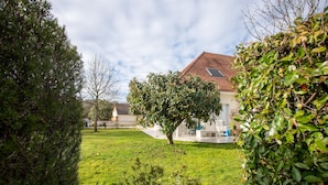 A residential property with a well-maintained lawn, a large tree, and a house with a sloped roof. - Guest Room in Laroin for 2 to 4 Guests – Nature and Tranquility Await (Laroin)