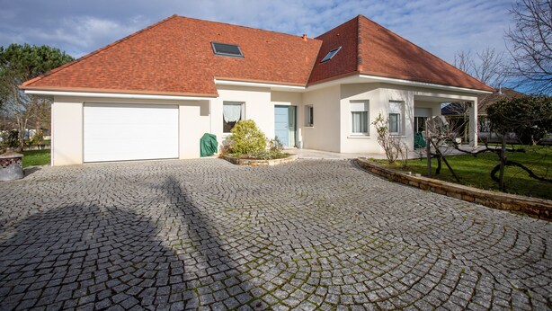 A two-story house with a red-tiled roof, a garage, and a cobblestone driveway. - Guest Room in Laroin for 2 to 4 Guests – Nature and Tranquility Await (Laroin)