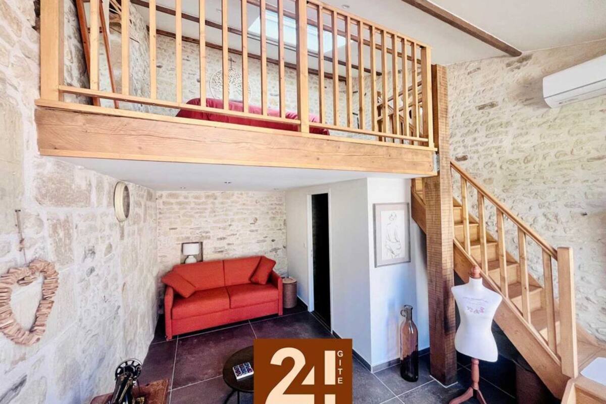 A loft-style room with a wooden staircase, a red sofa, and a mannequin.