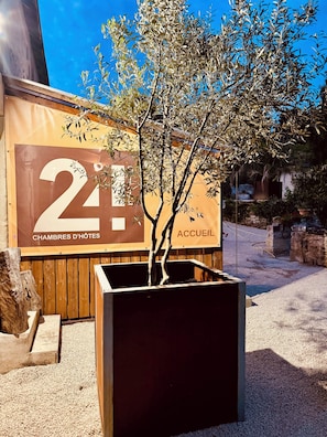 Entrada de hotel con un letrero grande que muestra '2' y 'CHAMBRES D'HÔTES', indicando el número de habitaciones y el tipo de alojamiento.