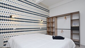 A modern bedroom with a patterned wall, a bed, a wardrobe, and a hanging light fixture. - Room 'Chambre 7' with Shared Terrace, Wi-Fi and Air Conditioning (Salies-du-Salat)
