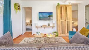 Een woonkamer met een bank, salontafel en een schilderij aan de muur.