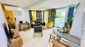 A modern living room with a sofa, chairs, a coffee table, and a dining area with a bench and table.
